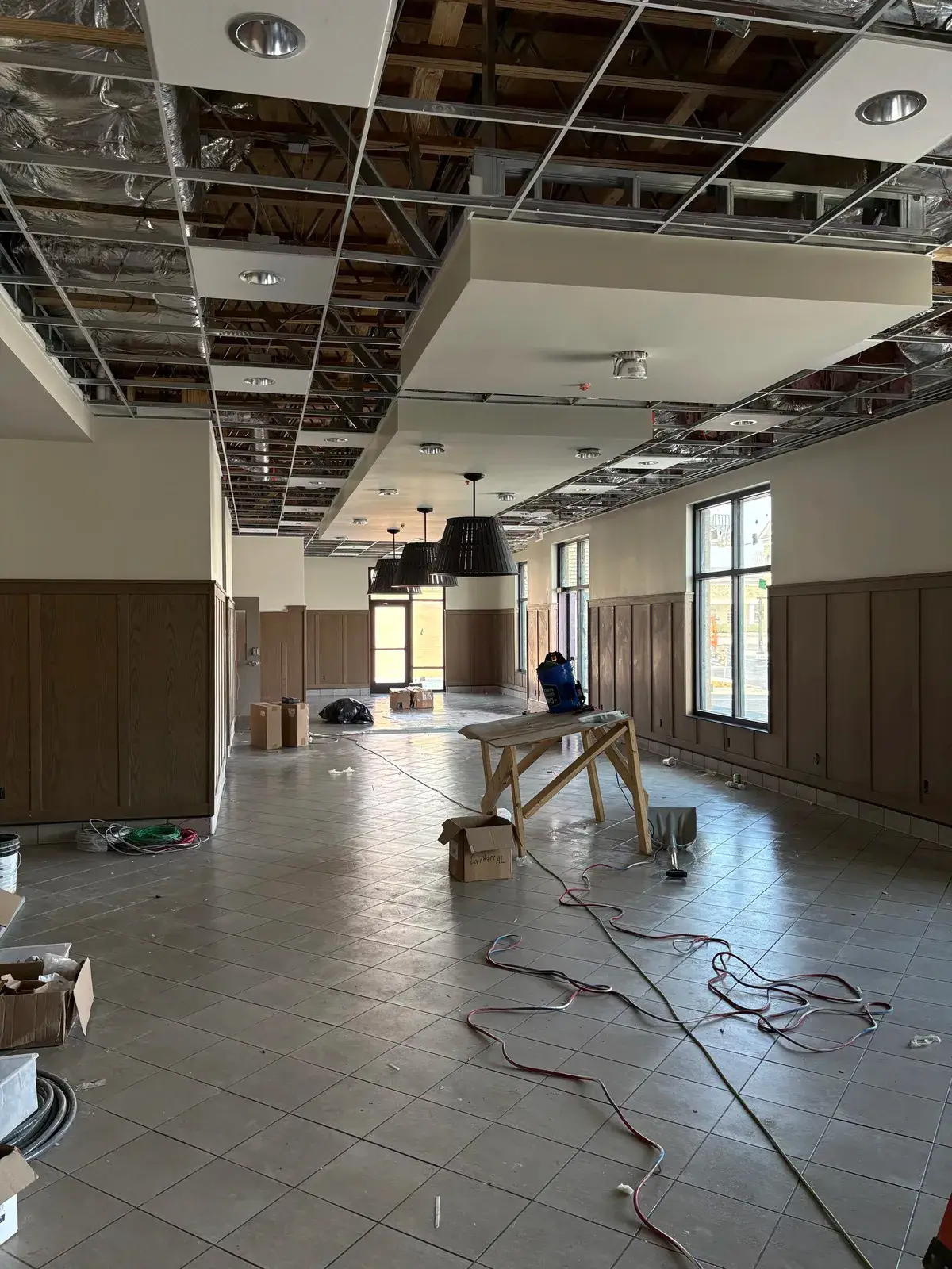 Dining-room pendant fixtures being installed during the finish phase of a Fairhope restaurant build